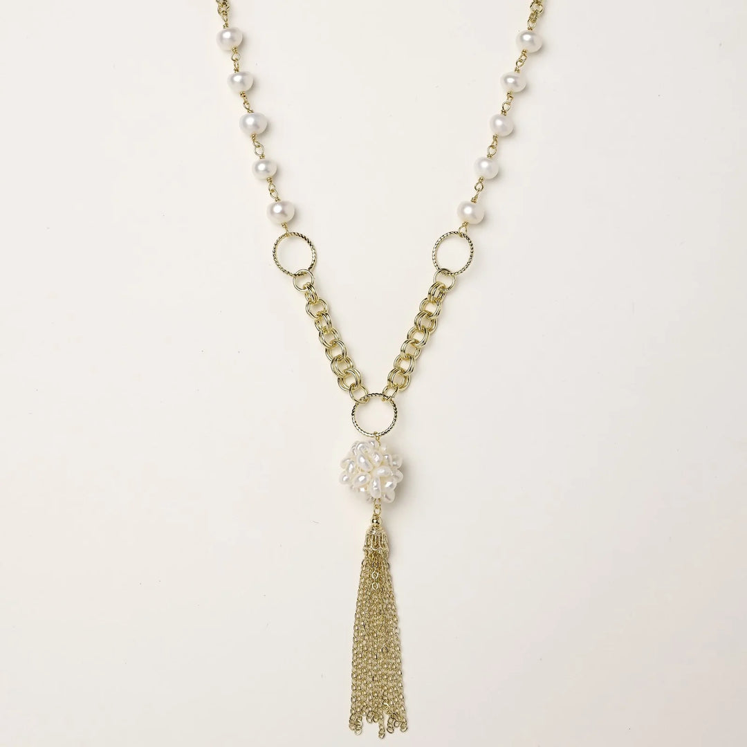 Long gold-plated necklace with freshwater pearls, chunky chain links, and flowing tassel pendant