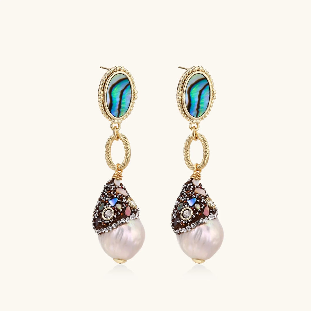 Gold drop earrings with iridescent abalone studs, rope links, jeweled caps and white baroque pearls on cream background