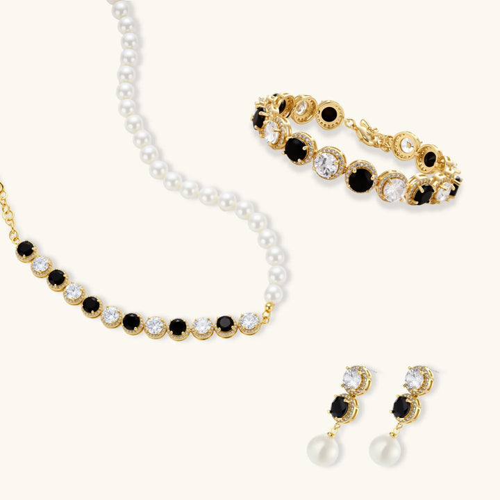 Gold-plated jewelry set with alternating black and clear cubic zirconia stones, featuring necklace, earrings and bracelet