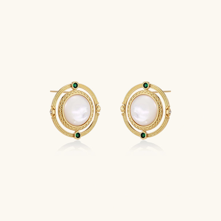 Circular gold stud earrings with iridescent mother-of-pearl center and green zirconia accents on cream background.
