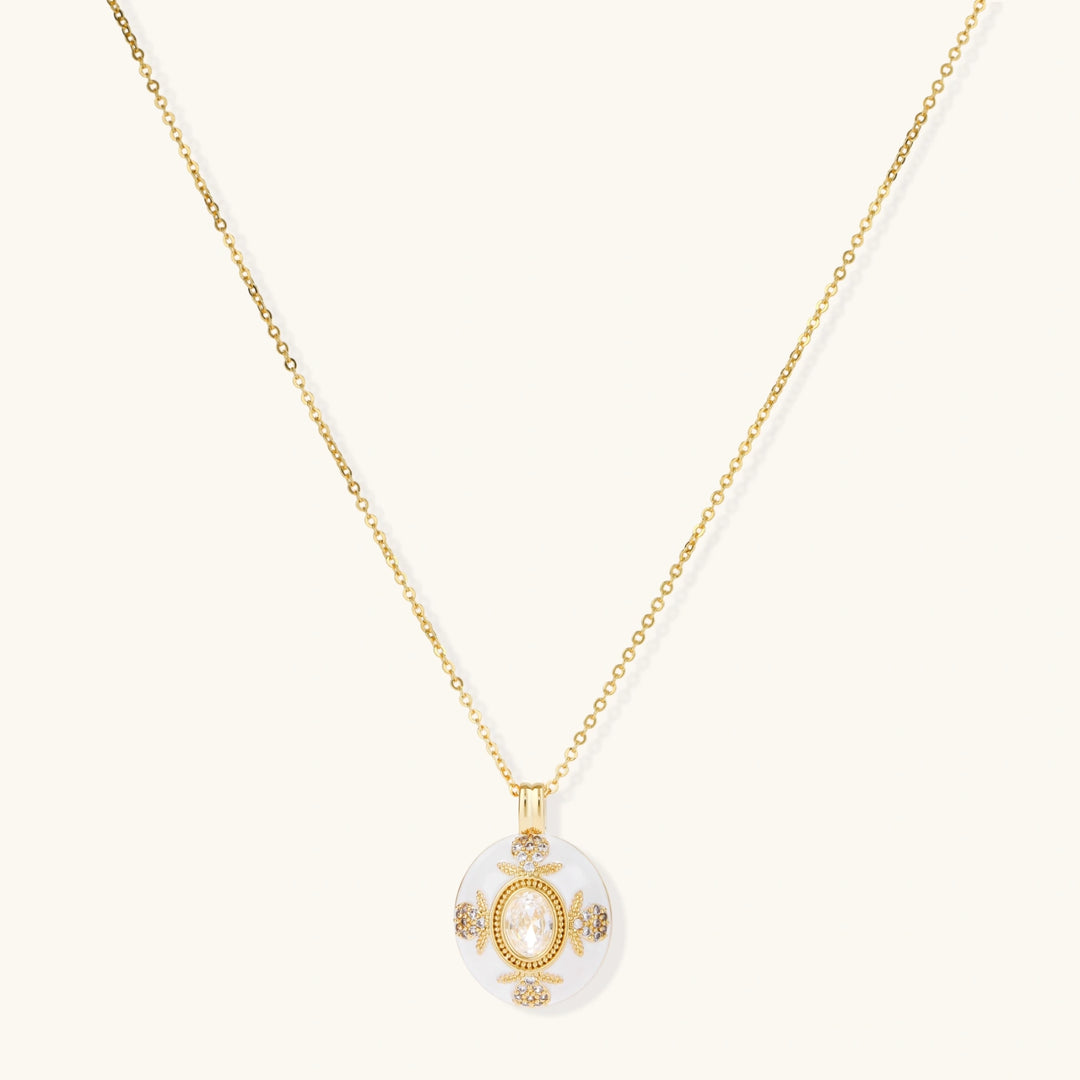 Gold-plated necklace with circular white enamel pendant featuring central zirconia stone and ornate decorative details