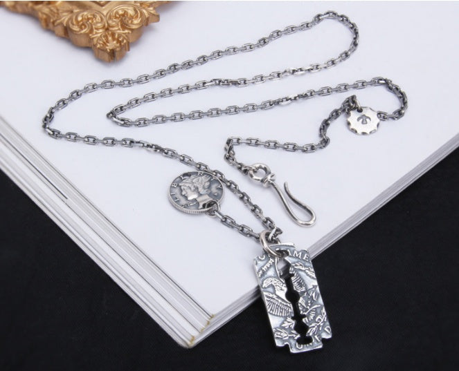 Morgan Blade 925 sterling silver necklace with geometric pendant on striped book